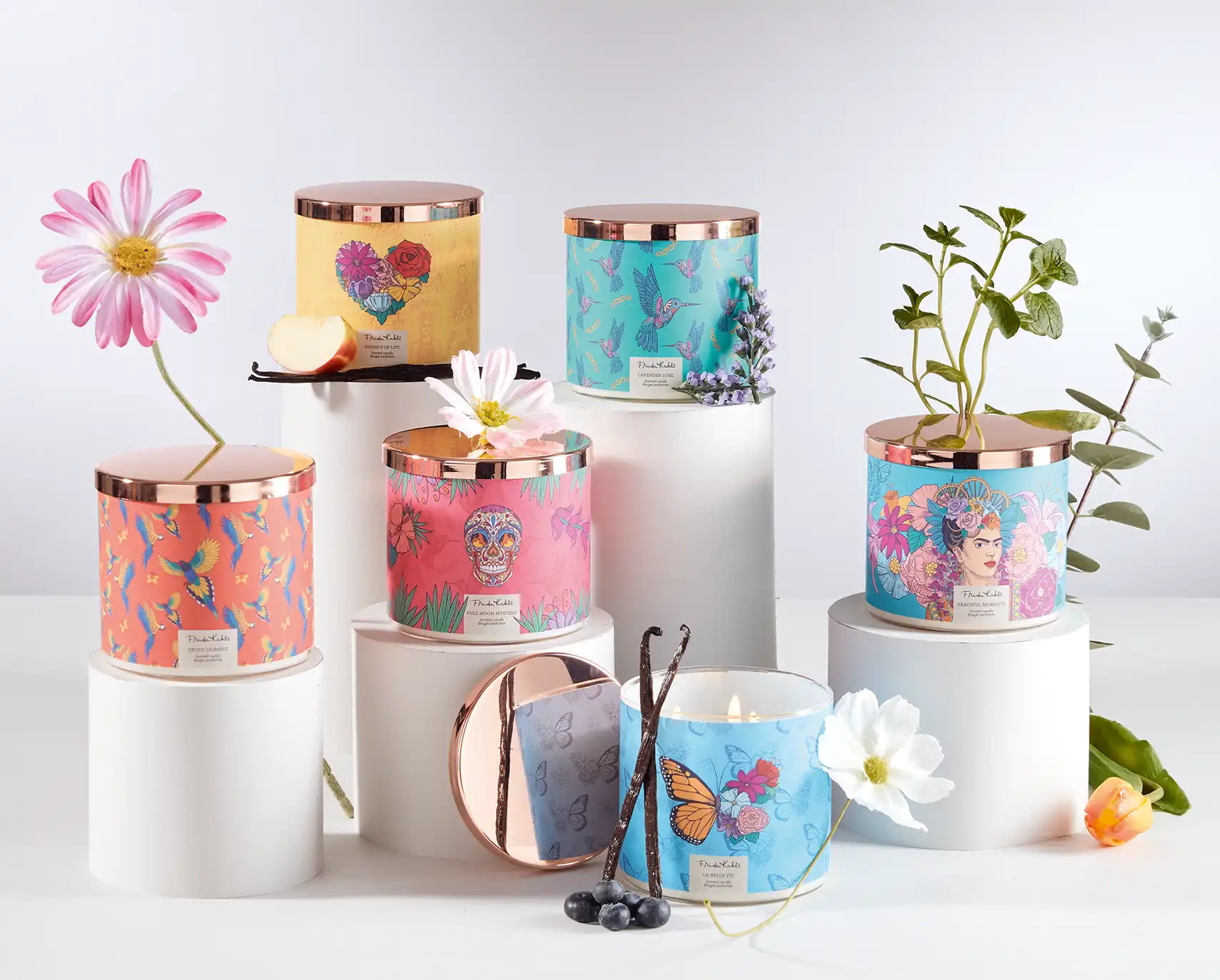 Bunte Duftkerzen mit Motiven der Künstlerin Frida Kahlo verziert mit Frühlingsblumen