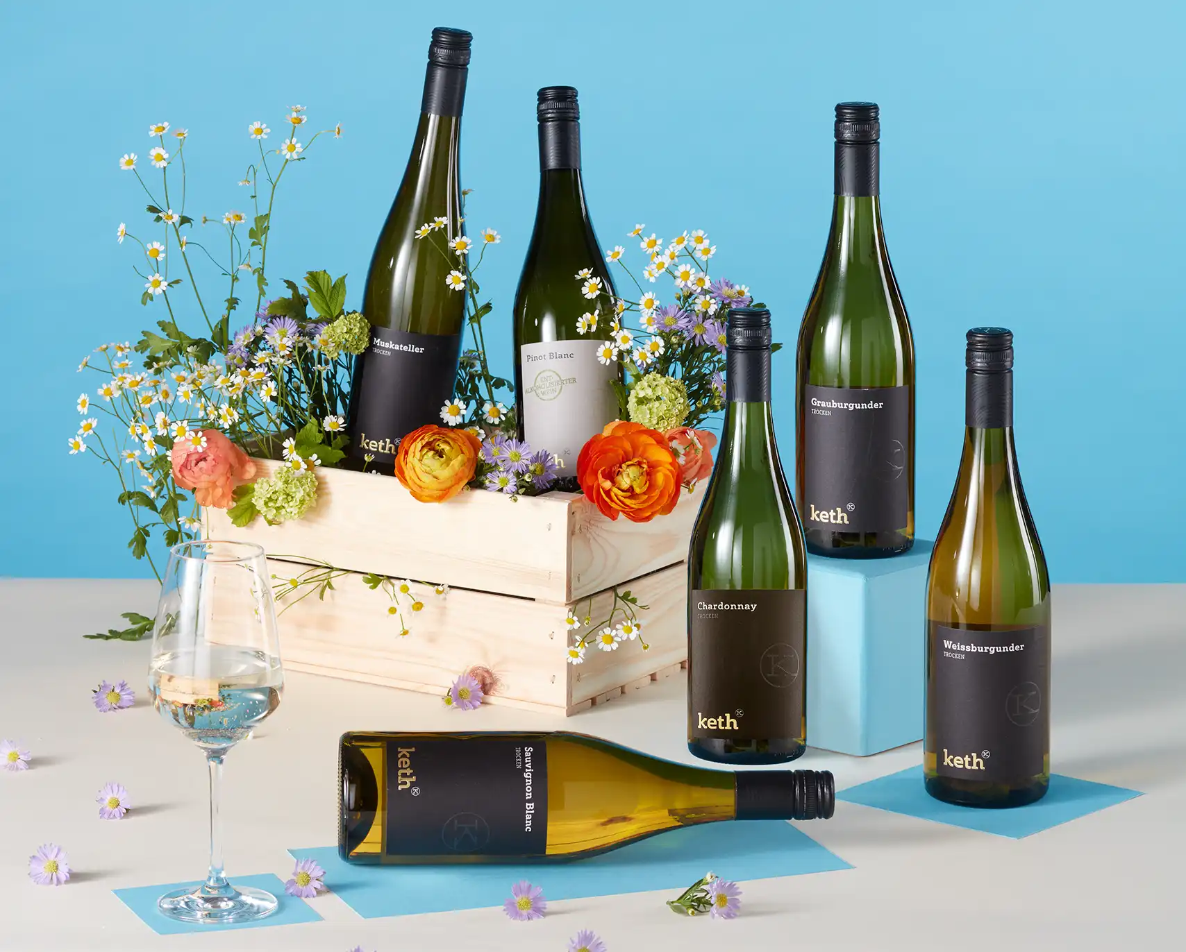 Weine von Keth in einer Kiste vor frühlingshafter Kulisse